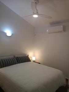 卡兰博希toni's apartament Menorca的卧室配有白色的床和吊扇