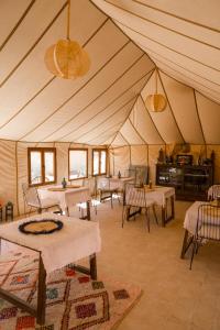 梅尔祖卡Beldi camp的一个带桌椅的大型帐篷