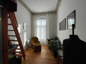 奥普尔Pokój nr 17的客厅设有楼梯、椅子和窗户
