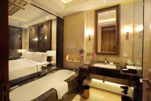 新德里新德里玛玉尔豪尔诺伊达皇冠假日酒店的一间带床、浴缸和水槽的浴室