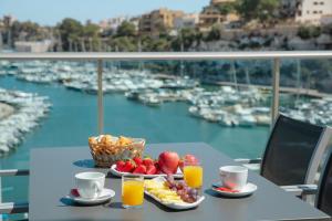 克里斯托港Porto Drach Aparthotel & Suites的一张桌子,上面放着一碗水果和一篮果汁