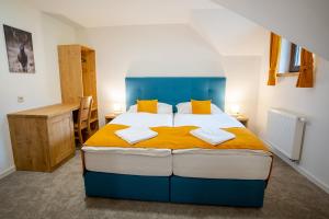 普利比利那Rezort pri jazere Podbanské的卧室配有蓝色和白色的床以及黄色枕头