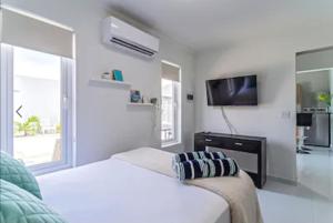 棕榈滩Bida Marino Residence Aruba的一间白色卧室,配有床和电视