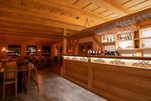 普利比利那Rezort pri jazere Podbanské的餐厅设有酒吧和桌椅