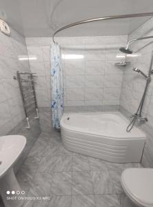 希瓦Khiva Tosh Darvoza的白色的浴室设有浴缸和水槽。