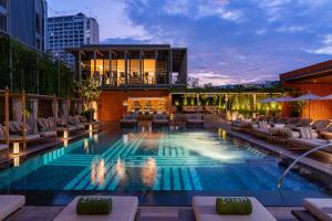 清迈Melia Chiang Mai的一座带躺椅的游泳池和一座建筑