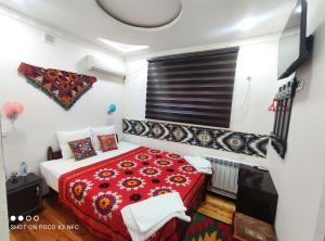 希瓦Khiva Tosh Darvoza的一间卧室配有红色的床和红色毯子