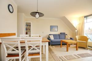 博尔滕哈根Papillon Wohnung 01-6的客厅配有桌子和蓝色沙发
