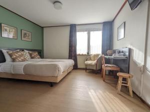 福尔登Hotel De Gravin van Vorden的一间卧室配有一张床、一张桌子和一把椅子
