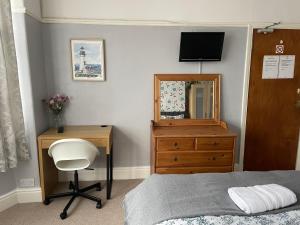 布里斯托枫叶宾馆 的一间卧室配有一张床、一张书桌和一面镜子