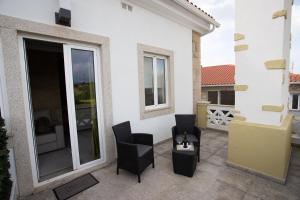 奥利维拉多霍斯比托Casa Moiano的一个带两张黑色椅子的庭院和一个阳台