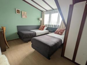 福尔登Hotel De Gravin van Vorden的一间小房间,配有两张床和一张沙发