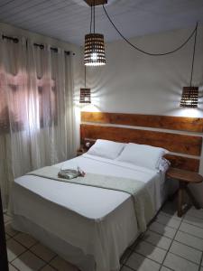 皮帕Pousada Mar e Sol的卧室配有一张带两个灯的大白色床