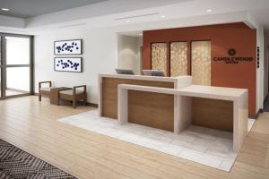 奥本希尔斯Candlewood Suites - Detroit - Auburn Hills, an IHG Hotel的一个带前台和椅子的办公大厅