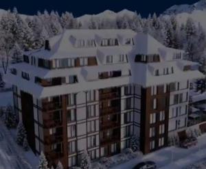 科帕奥尼克Family apartmans Hari - Apart Hotel & spa Zoned, Kopaonik - Children up to 13 years free!的雪中建筑物的 ⁇ 染