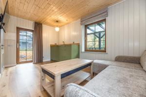 Želvė Village & SPA的客厅配有木桌和沙发