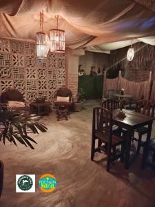皮帕Pousada Mar e Sol的用餐室配有桌椅和吊灯。