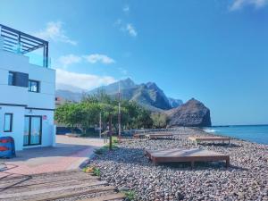 圣尼科拉斯村De Sebastian 1 - estudio frente al mar的山 ⁇ 海滩上的建筑和长椅