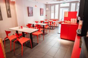 斯特拉斯堡Hotel des Arts - Centre Cathédrale的一间带红色桌椅和柜台的餐厅