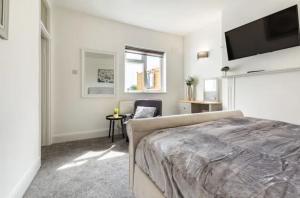 HornchurchLuxury 3-Bed Apartment Near To London With Parking的一间卧室配有一张床和一台平面电视