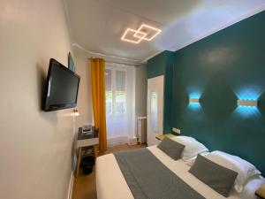 里昂Lyo Hôtel - Centre Lyon Perrache的一间卧室配有一张床,墙上配有电视