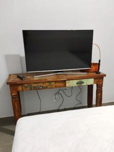 巴西利亚Apartamento aconchegante no Sudoeste的一张电视机,放在一张木桌旁的床边