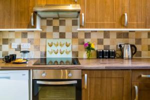 约克古德姆盖特公寓酒店的厨房配有木制橱柜和炉灶烤箱。