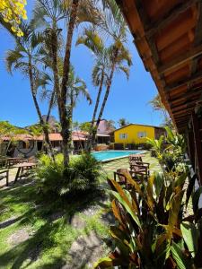 盖比姆Pousada das Gaivotas的从棕榈树度假村的门廊上可欣赏到风景,并设有一个游泳池
