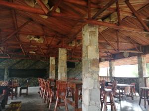 MasindiMurchison Backpackers的用餐室设有木制天花板和桌椅