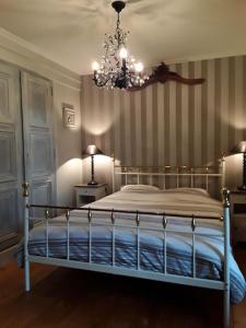Vakantiewoning Le Chêne的一间卧室配有一张带吊灯的床