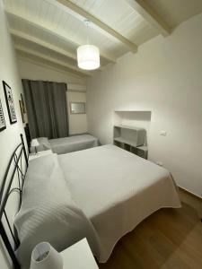 阿格里真托Dimora Garibaldi Apartment & Room的白色卧室配有床和沙发