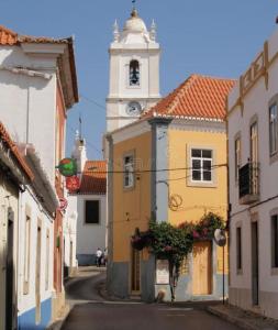 阿尔坎塔里利亚Casa Azul em Alcantarilha - Algarve的一条城市街道,远处有钟楼
