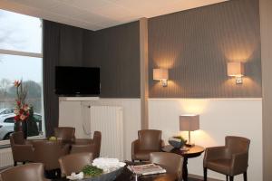 坎彭堤坝酒店的一间带椅子和桌子的房间以及一台电视