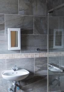 哈博罗内Haithoms Guesthouse的一间带水槽和镜子的浴室