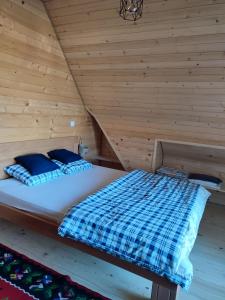 新瓦罗什Brvnara Pahuljica Zlatar的木墙客房的一张床位