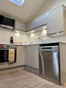 托德莫登The Coach House - *New Build in Traditional Style*的厨房配有不锈钢冰箱和炉灶。