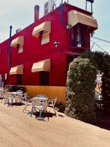 La ZarzaHostal Casa López的前面有桌椅的红色建筑