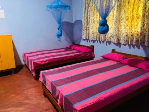 阿努拉德普勒Coco Garden Holiday Homes的配有粉红色和紫色床单的客房内的两张床