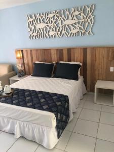 布希奥斯Hotel Búzios Resort com Entretenimento的一间卧室设有一张带木墙的大床