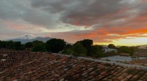格拉纳达Encuentros的屋顶上的日落,背景是山