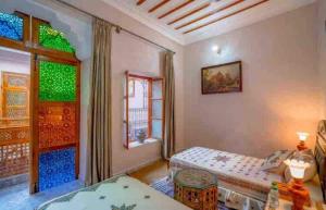 非斯Dar lmrama Guest House Fes Medina Morocco的一间卧室设有两张床和窗户。