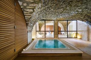 马莱莫尔LOCATION 4 personnes GOLF DE PONT ROYAL EN PROVENCE的一座带石墙的建筑中的室内游泳池