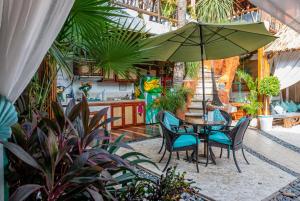 阿卡普尔科Monyoli Hotel & Boutique的庭院配有桌椅和遮阳伞。