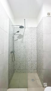 萨尔雷Ka Djula的浴室里设有玻璃门淋浴