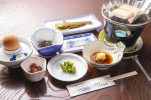 天川村Ichimaru Ryokan - Vacation STAY 59281v的餐桌上放着碗和盘子