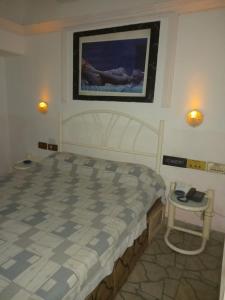 梅洛HOTEL PARQUE en Merlo- Buenos Aires的一间卧室配有一张床,桌子上配有一部电话
