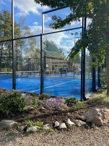 金洛伊Casa Nymphaea的一个带围栏和鲜花的网球场
