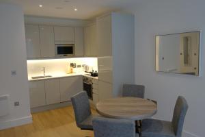 伯明翰Exceptional 1King Lifestyle Apartment - Centrally located的厨房配有木桌、椅子和水槽