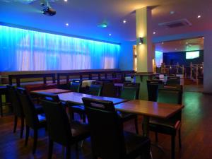 巴尔金Dreams Hotel的餐厅设有木桌和椅子,灯光蓝色