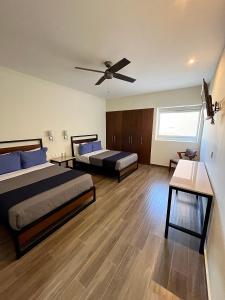 圣胡安－德洛斯拉戈斯Hotel Refugio的一间卧室配有两张床和吊扇